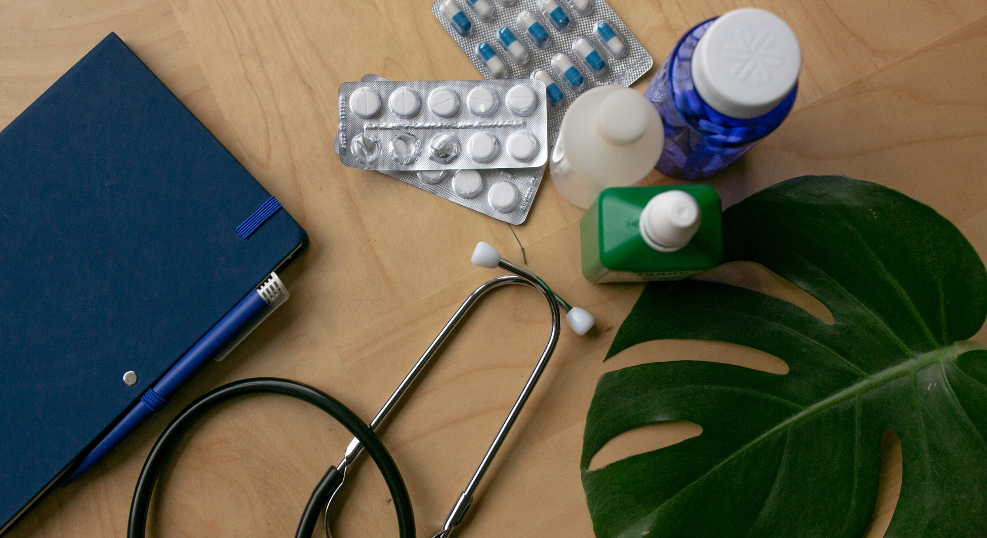 escritorio con decoración, medicamentos y una libreta